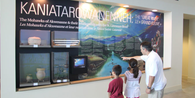 A family examines an exhibit about the history of the Akwesasne Mohawks.