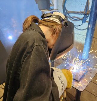 A student gets hands-on with a welding demonstration at the Mind Over Metal camp.