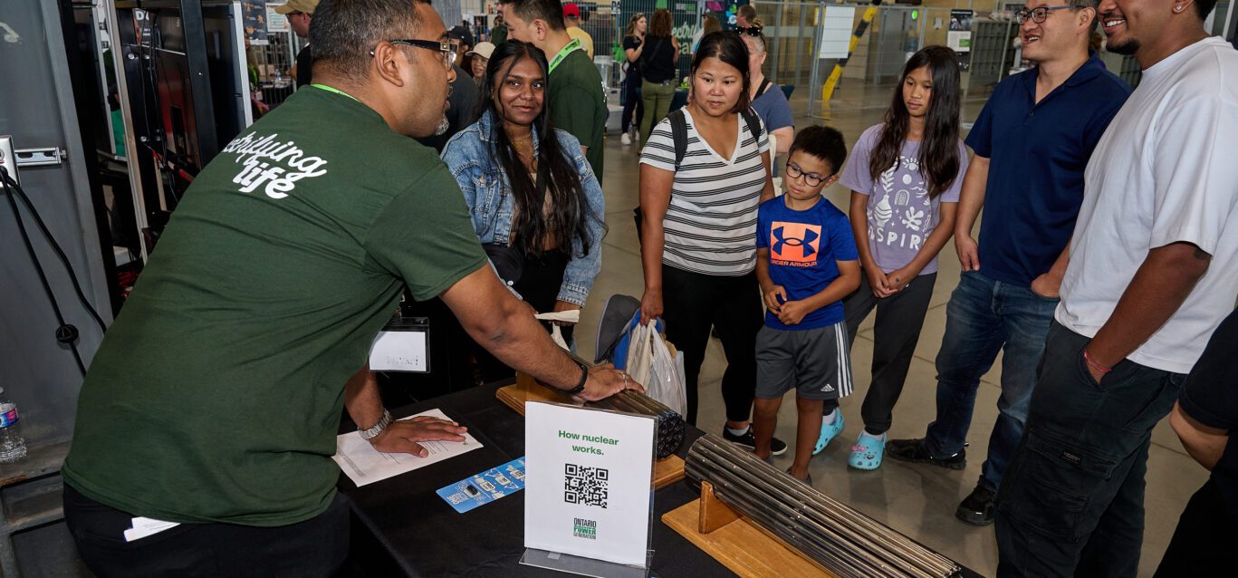 An OPG employee fields questions from the public at a community event.