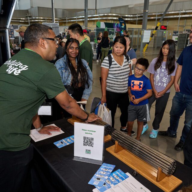 An OPG employee fields questions from the public at a community event.