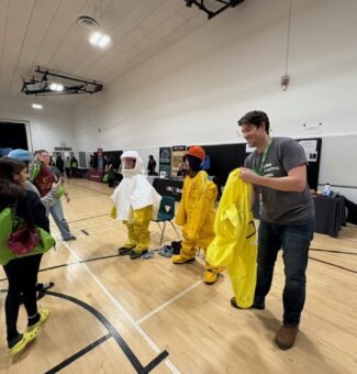 Students try on some protective gear for nuclear operations at a recent Trades Promoting Trades event in December.